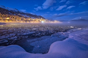 The frozen Inn river and the village of Sankt Moritz at dusk, Engadine, Canton of Grisons The frozen Inn river and the village of Sankt Moritz at dusk, Engadine, Canton of Grisons