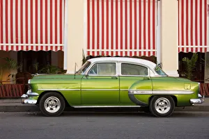 Green vintage American car parked in front of cafe, Cienfuegos, UNESCO World Heritage Site Green vintage American car parked in front of cafe, Cienfuegos, UNESCO World Heritage Site