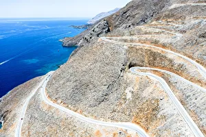 Hairpin bends of mountain road leading to the blue sea, aerial view, Crete island, Greek Islands, Greece, Europe Hairpin bends of mountain road leading to the blue sea, aerial view, Crete island, Greek Islands, Greece, Europe