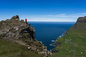 Hiker on The Postman's Trail to the village of Gasaldur, Vagar Island, Faroe Islands, Denmark, Europe Hiker on The Postman's Trail to the village of Gasaldur, Vagar Island, Faroe Islands, Denmark, Europe
