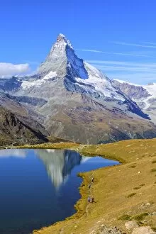 Images Dated 11th September 2011: Hikers walking on the path beside the Stellisee with the Matterhorn reflected, Zermatt