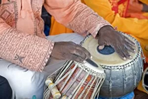 Hindu musician playing the tabla (drums) with typical black spot made from a mixture of gum
