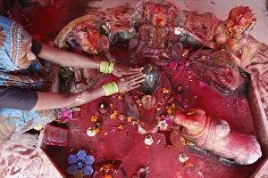 Hindu woman worshipping a lingam during Holi celebration in Goverdan, Uttar Pradesh Hindu woman worshipping a lingam during Holi celebration in Goverdan, Uttar Pradesh