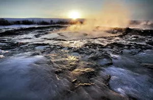 Heat Collection: Hot pools and steam from Strokkur Geysir at sunrise, winter, at geothermal area beside