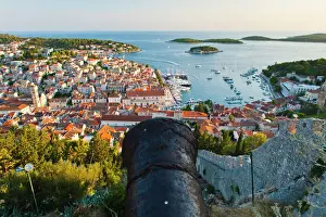 Prints of Hvar Fortress cannon and Hvar Town at sunset taken from the Spanish Fort (Fortica), Hvar Island, Dalmatian Coast, Adriatic, Croatia, Europe Croatia Prints: Hvar Fortress Cannon and Hvar Town at Sunset Print, Croatia