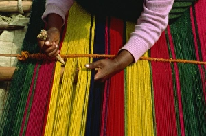An Indian woman weaving a carpet in small village by Lake Titicaca, Bolivia An Indian woman weaving a carpet in small village by Lake Titicaca, Bolivia