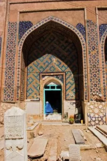Afghanistan Gallery: Lady pilgrim in blue burqa sitting in doorway at Sufi shrine of Gazargah