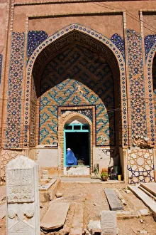 Afghanistan Gallery: Lady pilgrim in blue burqa sitting in doorway at Sufi shrine of Gazargah