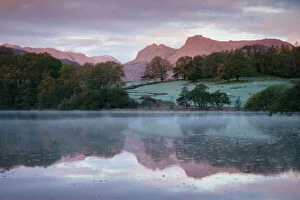 Langdale Pikes at dawn from Loughrigg Tarn, Lake District, Cumbria, England, United