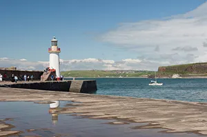 Lighthouse at entrance to outer harbour, motor yacht entering, Whitehaven Lighthouse at entrance to outer harbour, motor yacht entering, Whitehaven