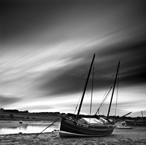 Long exposure used to record moving clouds above old wooden ketch on Aln Estuary at low Long exposure used to record moving clouds above old wooden ketch on Aln Estuary at low