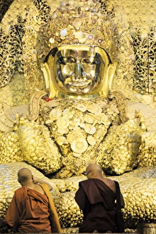 Mahamuni Paya (Mahamuni Buddhist temple), devotees praying and pressing gold leaf Mahamuni Paya (Mahamuni Buddhist temple), devotees praying and pressing gold leaf