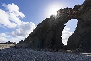 Majestic Arco del Juradonatural arch lit by sun on Pena Horadada beach, Betancuria Majestic Arco del Juradonatural arch lit by sun on Pena Horadada beach, Betancuria