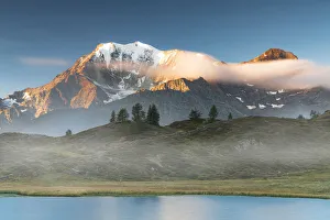 Majestic Fletschhorn and Galehorn peaks in autumn fog at dawn from Hopschusee lake Majestic Fletschhorn and Galehorn peaks in autumn fog at dawn from Hopschusee lake