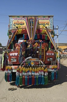 Man fixing decoration onto truck for Diwali celebrations, Pali district Man fixing decoration onto truck for Diwali celebrations, Pali district