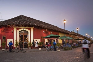 Man rideing bike past restaurant on Calle La Calzada, Granada, Nicaragua, Central America Man rideing bike past restaurant on Calle La Calzada, Granada, Nicaragua, Central America