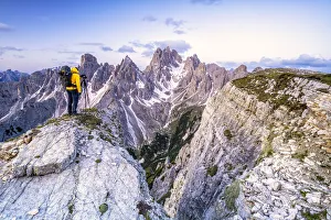Man on top of rocks photographing Cadini di Misurina at sunrise, Dolomites Man on top of rocks photographing Cadini di Misurina at sunrise, Dolomites