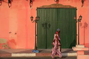 Man walking past a pink house, St. Louis, Senegal, West Africa, Africa