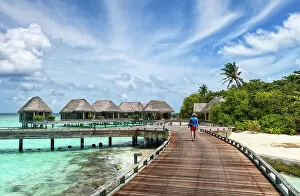 Maldives Gallery: Man walking on a wooden jetty, Baa Atoll, Maldives, Indian Ocean, Asia