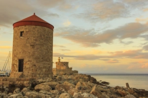 Mandraki Harbour medieval windmill and Fortress at sunset, Rhodes Town, UNESCO World Heritage Site Mandraki Harbour medieval windmill and Fortress at sunset, Rhodes Town, UNESCO World Heritage Site