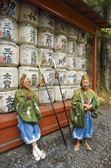 Men traditional clothing sitting in front of colourful sake barrels Men traditional clothing sitting in front of colourful sake barrels