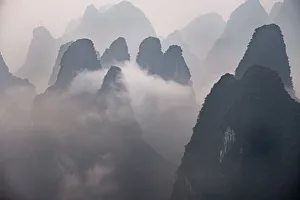 Misty morning with fog and low clouds on the peaks above Li River, Guangxi, China, Asia Misty morning with fog and low clouds on the peaks above Li River, Guangxi, China, Asia