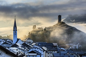 Misty sky on the alpine village of Ardez at sunrise, district of Inn, Lower Engadine Misty sky on the alpine village of Ardez at sunrise, district of Inn, Lower Engadine