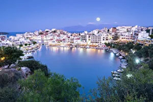 Moonlight over the old town of Agios Nikolaos and lake at dusk, Lasithi prefecture, Crete Moonlight over the old town of Agios Nikolaos and lake at dusk, Lasithi prefecture, Crete