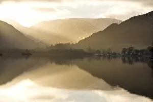 Images Dated 12th December 2010: Morning sunlight bursting through clouds over fells with reflections in Lake Ullswater