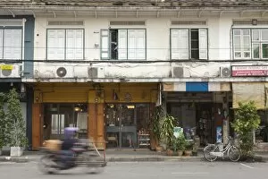 Motor Bike Gallery: A motorbike rides past a shop front in Rattanakosin, Bangkok, Thailand, Southeast Asia, Asia