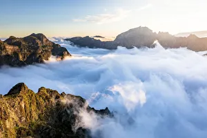 Mountain peaks emerging from clouds at sunset view from Pico Ruivo, Madeira, Portugal Mountain peaks emerging from clouds at sunset view from Pico Ruivo, Madeira, Portugal