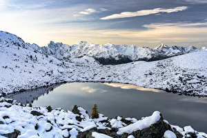 Mountain peaks of Orobie Alps covered with snow reflecting in the frozen Rogneda lake at Mountain peaks of Orobie Alps covered with snow reflecting in the frozen Rogneda lake at