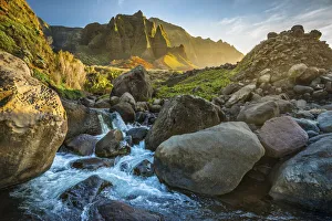 A mountain stream flows down at sunset in Kauai's Kalalau Valley, Hawaii A mountain stream flows down at sunset in Kauai's Kalalau Valley, Hawaii