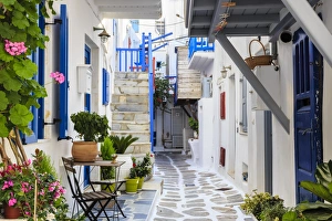 Narrow street, whitewashed buildings with blue paint work, flowers, Mykonos Town (Chora) Narrow street, whitewashed buildings with blue paint work, flowers, Mykonos Town (Chora)