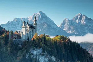 German Culture Gallery: Neuschwanstein Castle surrounded by colorful woods and snowy peaks, Fussen, Bavaria