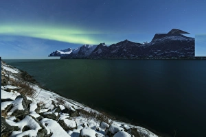 Northern Lights and stars over Senjahopen peak surrounded by the frozen sea, Senja Northern Lights and stars over Senjahopen peak surrounded by the frozen sea, Senja