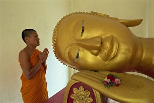 Novice monk and reclining Buddha, Wat Pha Baat Tai, Luang Prabang, Laos Novice monk and reclining Buddha, Wat Pha Baat Tai, Luang Prabang, Laos