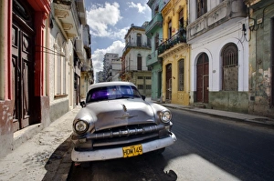 Old American Plymouth car parked on deserted street of old buildings, Havana Centro Old American Plymouth car parked on deserted street of old buildings, Havana Centro