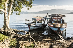 Old rusty fishing boats in a village at Lake Toba (Danau Toba), North Sumatra, Indonesia Old rusty fishing boats in a village at Lake Toba (Danau Toba), North Sumatra, Indonesia