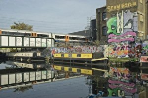 Hackney Wick Gallery: Overground train drives past canal by artists studios and warehouses in Hackney Wick
