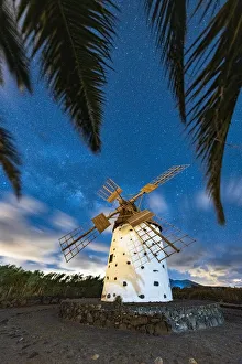 Palm trees framing a lone windmill under Milky Way, El Cotillo, La Oliva, Fuerteventura Palm trees framing a lone windmill under Milky Way, El Cotillo, La Oliva, Fuerteventura