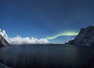 Panorama of the Northern Lights on the Senjahopen peak surrounded by the frozen sea Panorama of the Northern Lights on the Senjahopen peak surrounded by the frozen sea