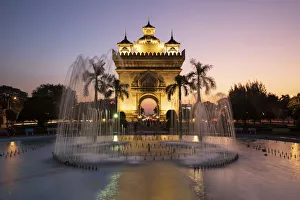 Patuxai Victory Monument (Vientiane Arc de Triomphe) and fountain floodlit at dusk Patuxai Victory Monument (Vientiane Arc de Triomphe) and fountain floodlit at dusk