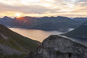 People admiring the sky at dawn standing on mountain top above the fjords, Senja island People admiring the sky at dawn standing on mountain top above the fjords, Senja island