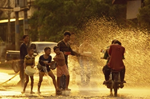 People on a motorbike being showered with water by People on a motorbike being showered with water by