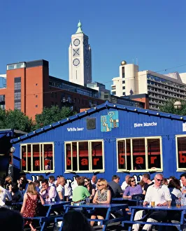 People sitting outside a bar on Gabriels Wharf, with the Oxo Tower behind People sitting outside a bar on Gabriels Wharf, with the Oxo Tower behind