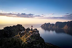 Person contemplating sunset from top of mountains, Senja island, Troms county, Norway Person contemplating sunset from top of mountains, Senja island, Troms county, Norway