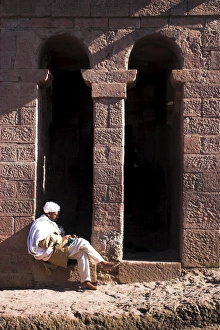 Pilgrim sits in early morning sun reading his Holy Bible at entrance doors to Bet Maryam Pilgrim sits in early morning sun reading his Holy Bible at entrance doors to Bet Maryam