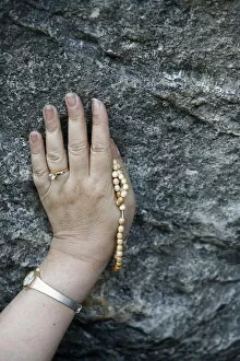 Images Dated 20th April 2000: Pilgrim touching the Lourdes grotto, Lourdes, Hautes Pyrenees, France, Europe