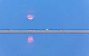 The pink full moon is reflected in the blue water of the Notteri pond, Villasimius The pink full moon is reflected in the blue water of the Notteri pond, Villasimius